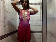 امرأة شابة من العرق الأبيض تأخذ حمامًا رطبًا وتلعب في ملابس داخلية من البنطلون الوردي