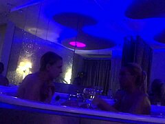 To blonde kvinder deltager i en dampende lesbisk scene i badekarret