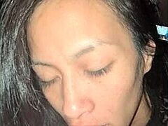 Una MILF asiática disfruta de una mamada profunda con juego de pezones y masaje